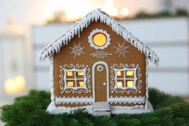 Güzel zencefilli kurabiye evi ve kapalı alanda köknar dalları, yakın çekim. Noel atmosferi