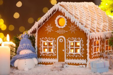 Güzel zencefilli kurabiye evi ve Noel dekoru bulanık ışıklara karşı, yakın plan