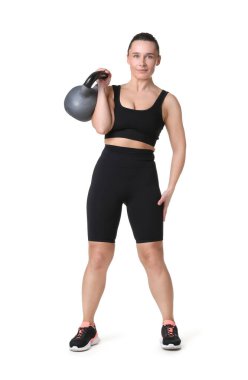 Beyaz arka planda kettlebell egzersizi yapan atletik kadın.