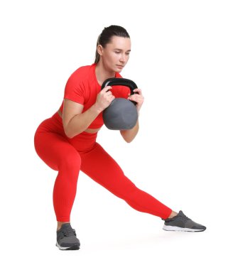 Beyaz arka planda kettlebell egzersizi yapan atletik kadın.