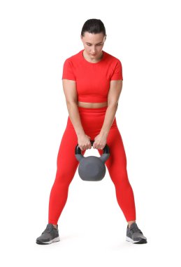 Beyaz arka planda kettlebell egzersizi yapan atletik kadın.