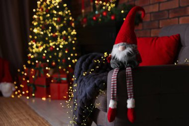Süslü odada koltukta komik bir noel cücesi. Metin için boşluk