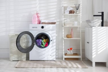 Modern çamaşır makinesi, deterjanlar ve iç çamaşırları.