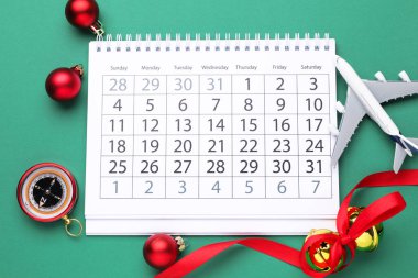 Noel tatili. Takvim, oyuncak uçak, pusula ve turkuaz arka plan süsleri, düz konum