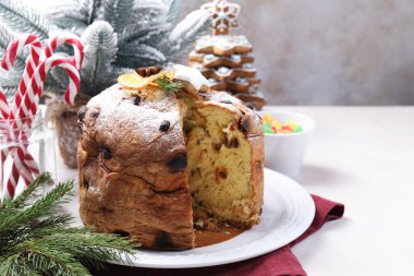 Lezzetli noel panettone pastası pudra şekeri ve beyaz masa üzerinde şenlikli dekor, yakın plan.