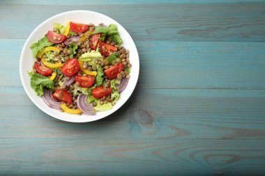 Açık mavi ahşap masada mercimek ve sebzeli nefis salata, üst manzara. Metin için boşluk
