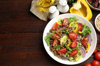 Lezzetli mercimek salatası ve ahşap masa üzerindeki malzemeler, düz yatak. Metin için boşluk