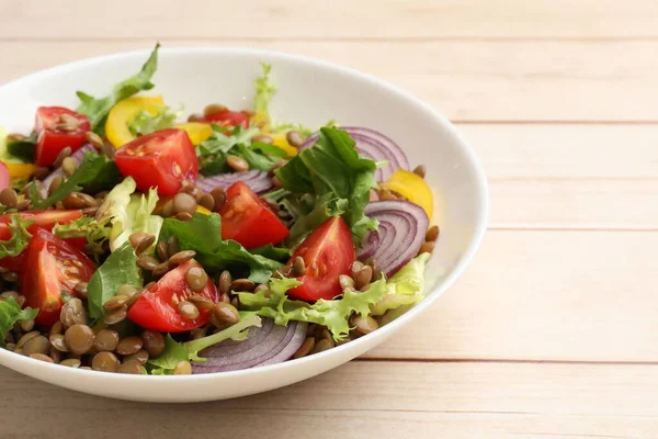 Hafif ahşap masada mercimek ve sebzeli nefis salata, yakın plan. Metin için boşluk