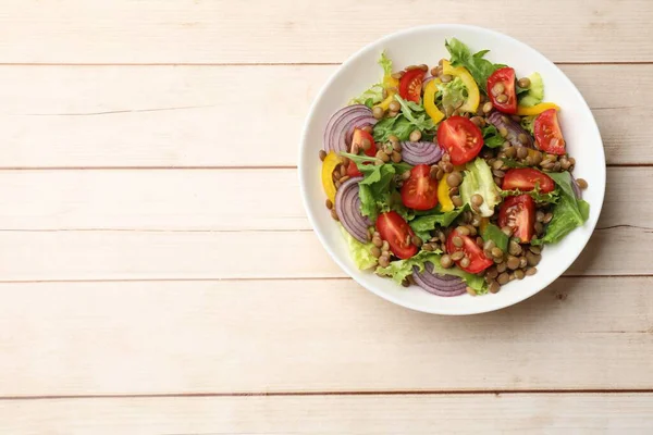 Hafif ahşap masada mercimek ve sebzeli nefis salata, üst manzara. Metin için boşluk