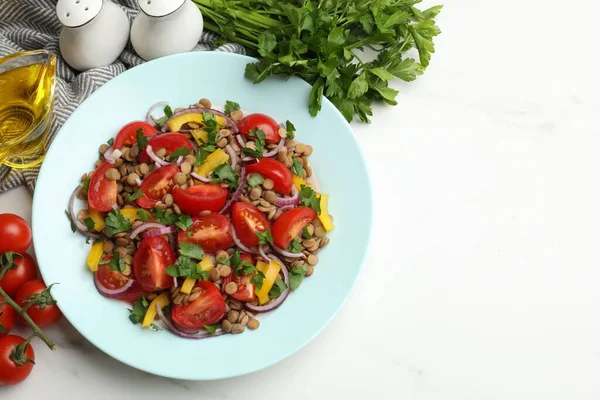 Lezzetli mercimek salatası ve beyaz mermer masa üzerindeki malzemeler, düz yatak. Metin için boşluk