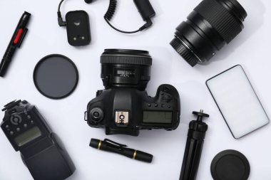 Beyaz arka planda profesyonel fotoğrafçı ekipmanı var.