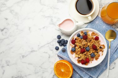 Lezzetli bir kahvaltı. Yoğurtlu granola ve beyaz mermer masada servis edilen meyveler. Metin için boşluk