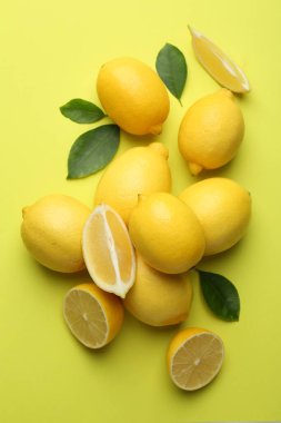 Taze olgun limonlar ve sarı arka planda yapraklar.