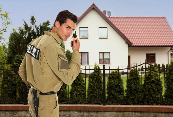 Güvenlik görevlisi evin yakınındaki telsizi kullanıyor. Özel mülk koruması