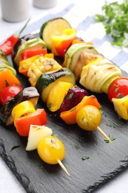 Skewers with tasty grilled vegetables on light table, closeup