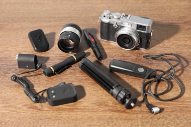 Ahşap arka planda farklı profesyonel fotoğrafçı ekipmanları var.