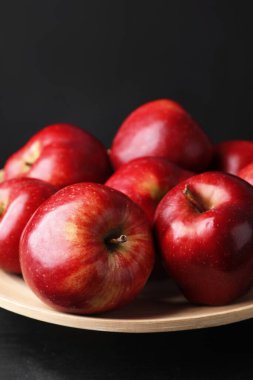 Olgun kırmızı elmalar ahşap masada siyah arkaplana karşı, yakın plan