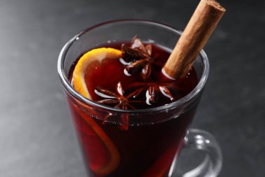 Siyah masada cam bardakta lezzetli bir şarap, yakın plan.