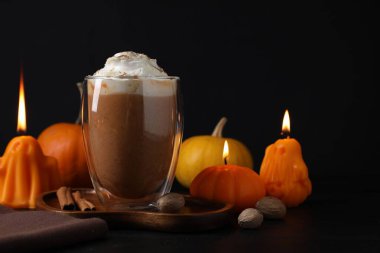 Krem şantili balkabaklı latte ve siyah arka planda sonbahar dekoru, yakın plan. Metin için boşluk