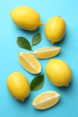 Taze olgun limonlar ve açık mavi arka planda yapraklar.