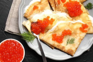 Lezzetli krepler kırmızı havyarlı ve ekşi kremalı siyah desenli masa, düz.