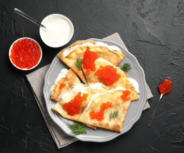 Lezzetli krepler kırmızı havyarlı ve ekşi kremalı siyah desenli masa, düz.