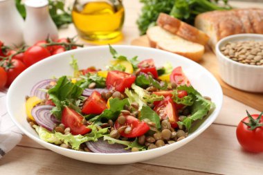 Lezzetli mercimek salatası ve malzemeler açık ahşap masada, yakın plan.