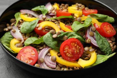 Gri masada mercimek ve sebzeli lezzetli salata, yakın plan.