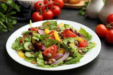 Gri desenli masada mercimek ve sebzeli lezzetli salata, yakın plan.