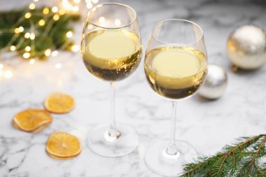 Beyaz şarap kadehleri ve noel dekoru açık mermer masada, yakın plan.
