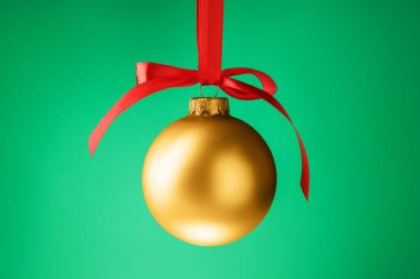 Yeşil arka planda sallanan bir Noel topu, yakın plan.