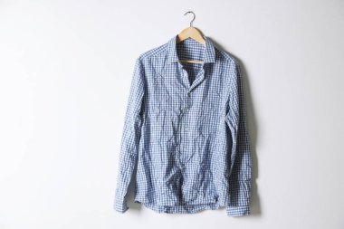 Işık duvarının yanında kareli gömlekli bir askı.