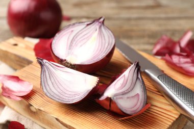 Masada soyulmuş soğan soğanları ve bıçak, yakın plan.