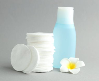 Temiz pamuk pedleri, deniz suyu ve açık gri arka planda çiçek yığını