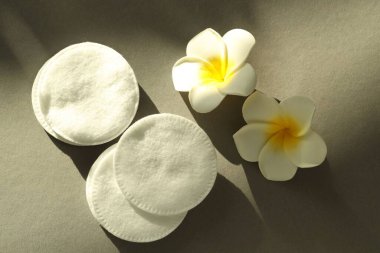 Gri arka planda temiz pamuk pedler ve çiçekler, düz yatıyordu.