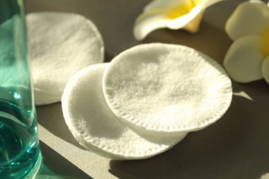 Gri arkaplanda temiz pamuk pedler ve çiçekler, yakın plan.