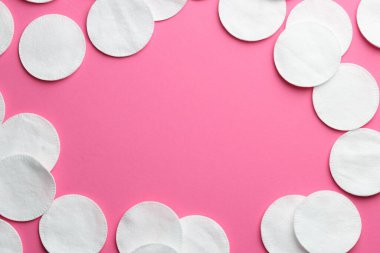Pembe arka planda temiz pamuk pedlerin çerçevesi düz. Metin için boşluk