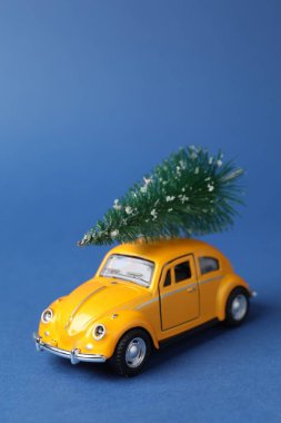 Noel tatili. Mavi arkaplanda ağaç olan oyuncak araba, metin için boşluk