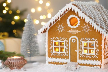 Güzel zencefilli kurabiye evi ve masada bulanık ışıklara karşı Noel süsü, mesaj için yer. Bokeh etkisi