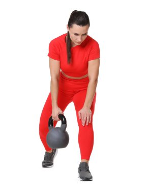 Beyaz arka planda kettlebell egzersizi yapan atletik kadın.