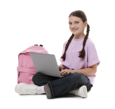 Beyaz arka planda dizüstü bilgisayarı ve sırt çantası olan tatlı bir kız.