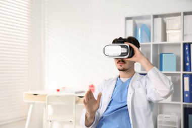 Modern teknoloji. Ofiste sanal ekranı kullanan kulaklıklı bir doktor. Metin için boşluk