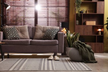 Oturma odasının içi rahat kanepe, diğer mobilyalar ve dekorlarla dolu.