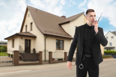 Güvenlik görevlisi evin yakınındaki telsizi kullanıyor. Özel mülk koruması