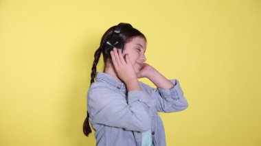 Sarı arka planda kulaklıklı tatlı kız.