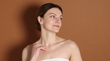 Kahverengi arka planda normal tenli güzel bir kadın.