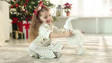 Evde güzel peri figürleriyle oynayan sevimli küçük bir kız.