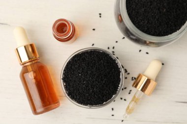 Siyah kimyon tohumları ve gerekli yağ şişeleri açık ahşap masa üzerinde, düz yatıyordu.