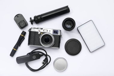 Beyaz arka planda profesyonel fotoğrafçı ekipmanı var.