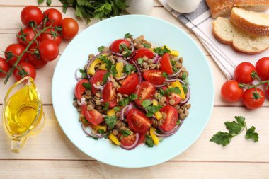 Lezzetli mercimek salatası ve malzemeler açık ahşap masada, düz yatıyordu.
